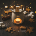 Gingerbread Marshmallow wax melt in a ceramic burner surrounded by festive props and warm candlelight