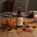 Pumpkin Spiced Latte Room Spray bottle surrounded by autumn props on a warm wooden surface